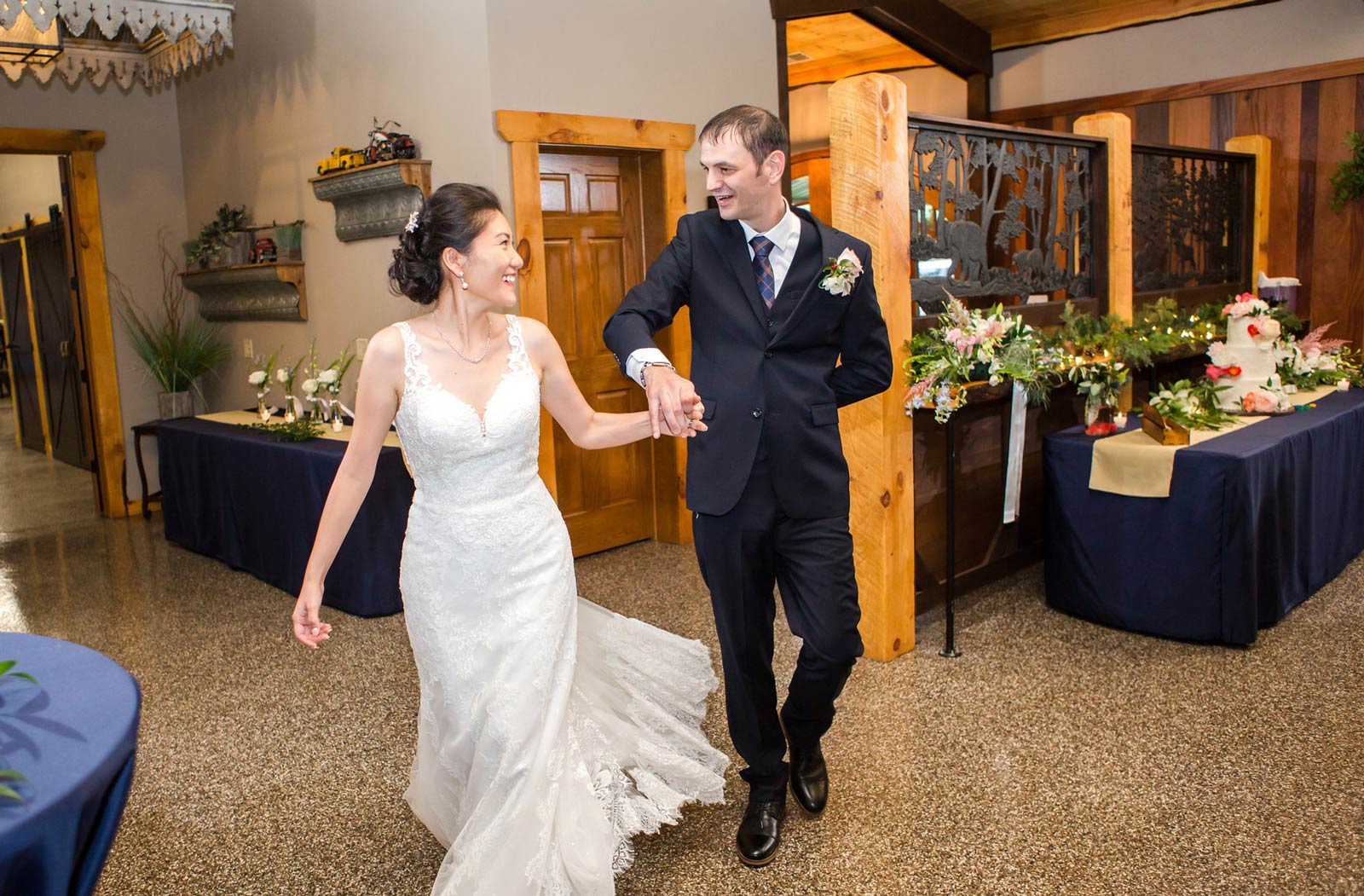 Bride and groom walking into reception room