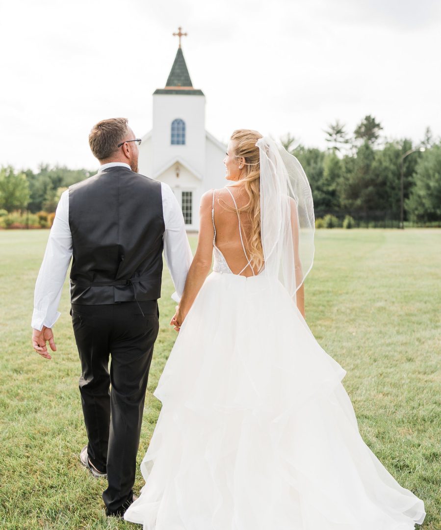 Bride and groom walking towards chapel