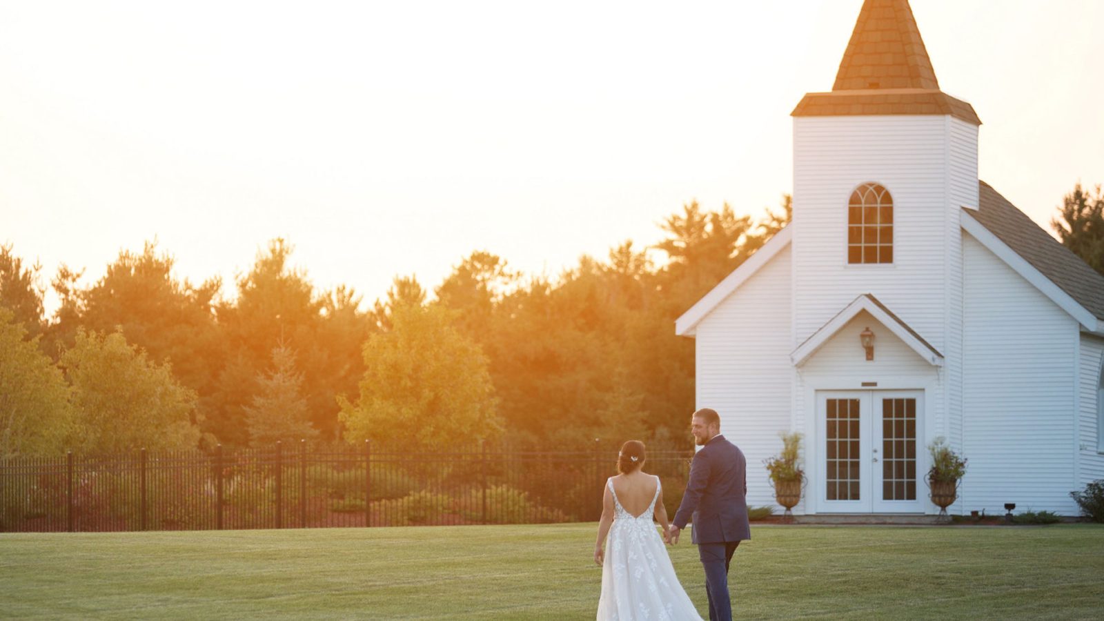 Bride and groom in front of Clara’s Chapel at sunset