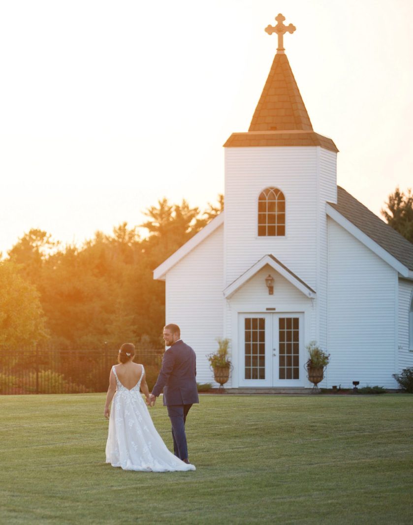 Bride and groom in front of Clara’s Chapel at sunset