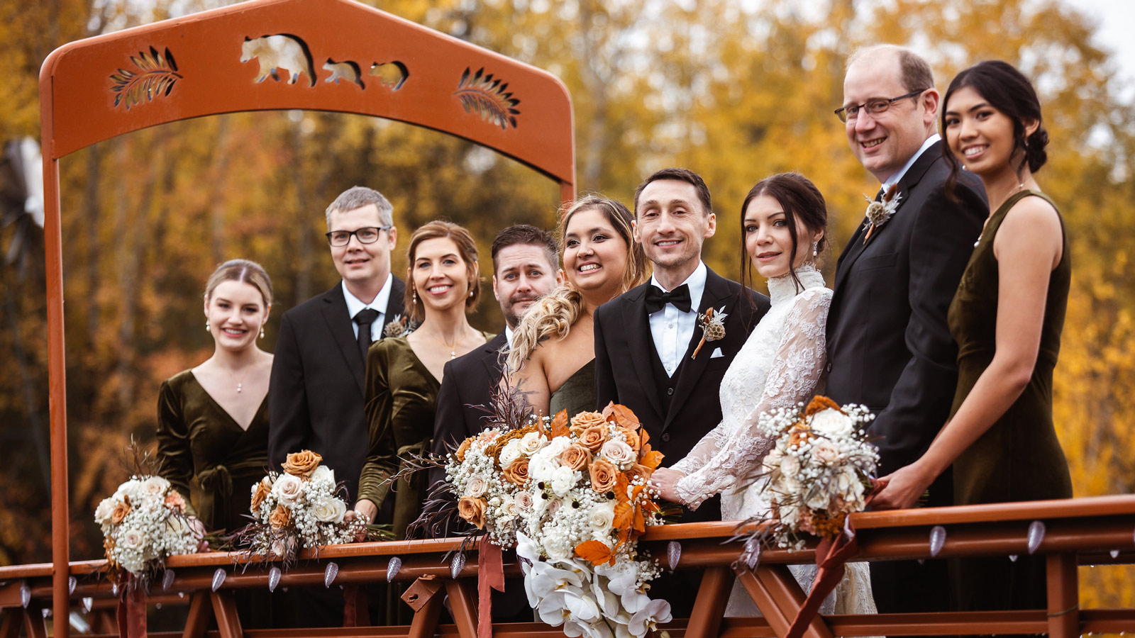 Wedding party posing on bridge in fall